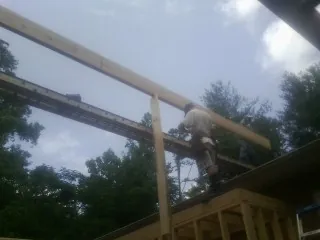 Carpenter setting a ridge beam over a new addition frame — Ice Dam Removal by Roofing Brothers in Chebeague Island