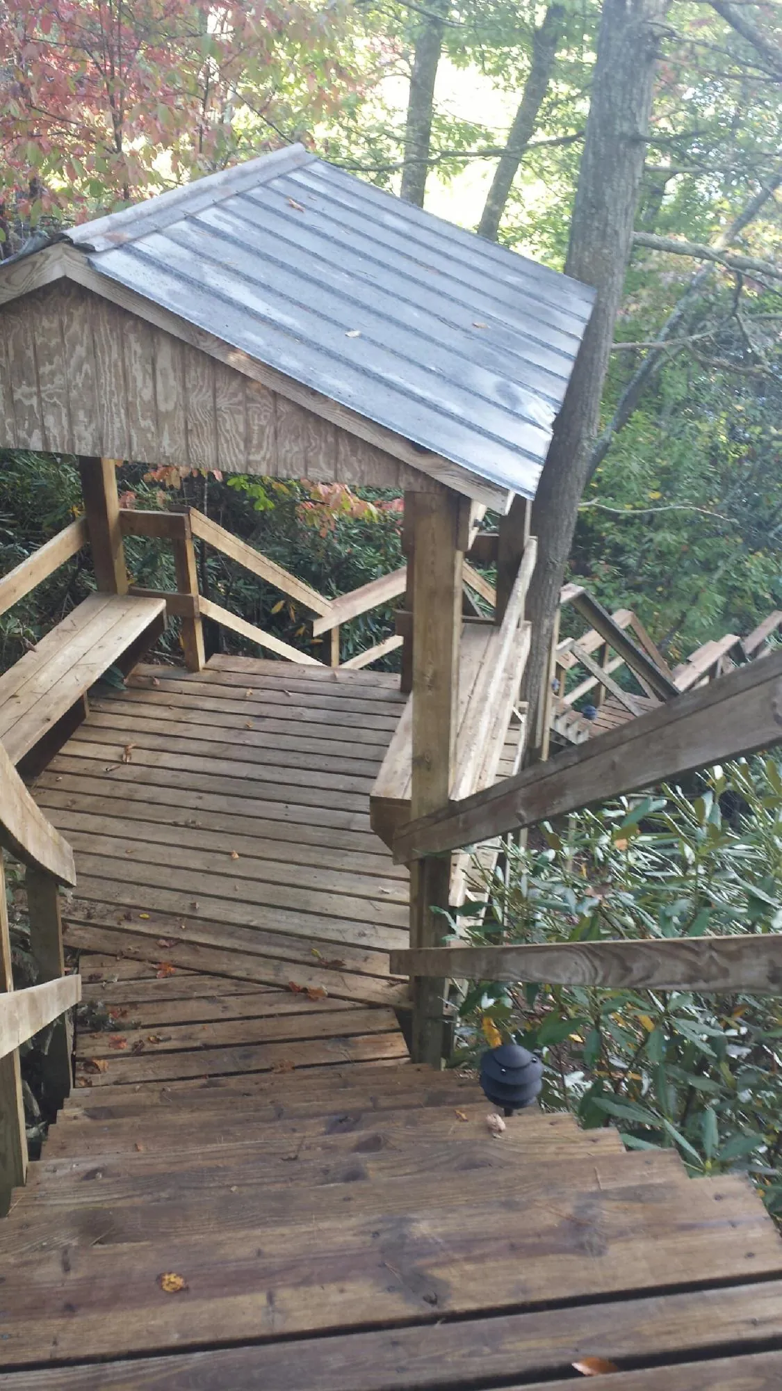Metal roofed shelter over wooden steps on a wooded walkway — Skylight Repair & Installation work by our crew in Chebeague Island