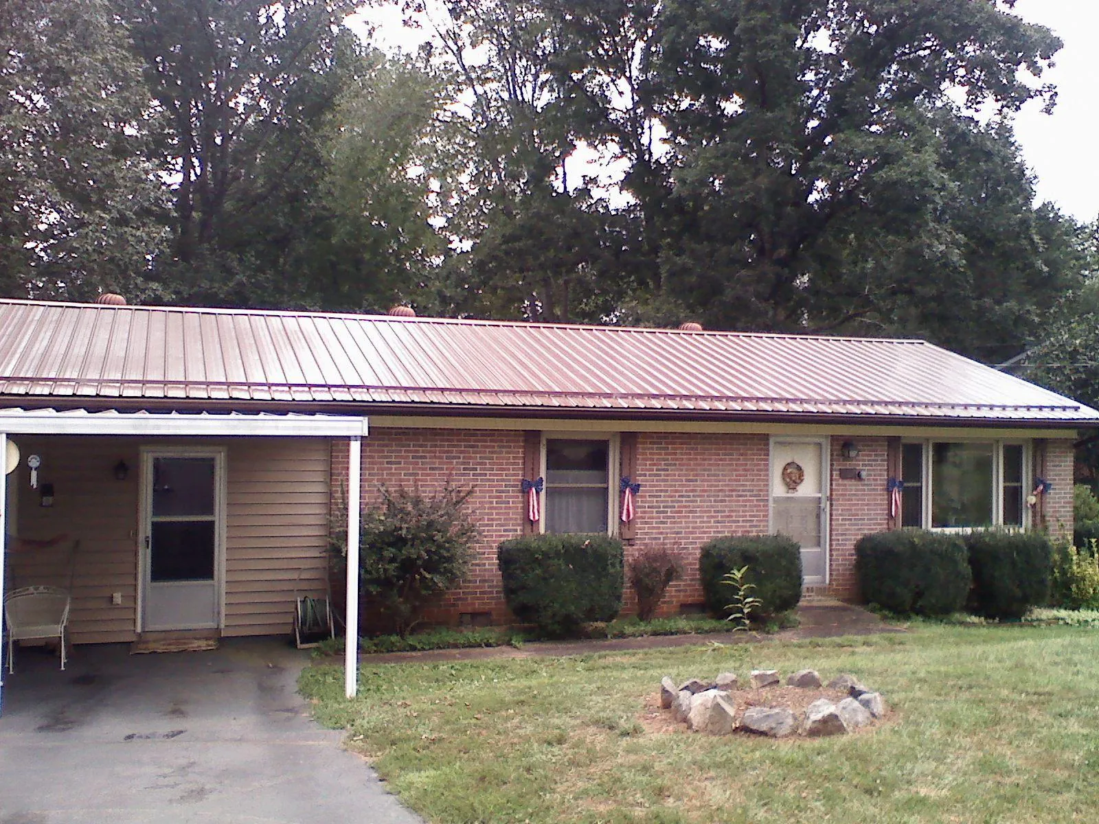 Bronze metal roof and carport on a brick ranch home — Roof Repair work by our crew in Chebeague Island